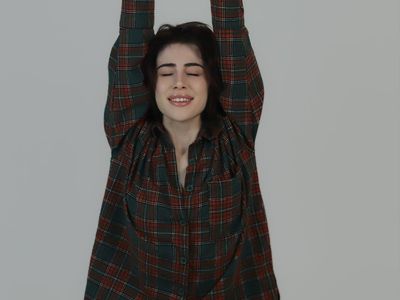 Person in a calm, meditative pose against a simple background.